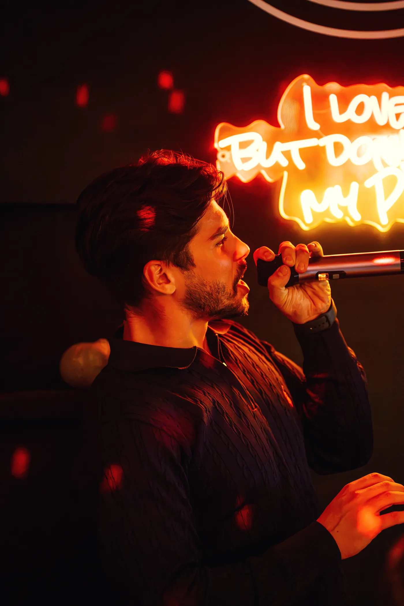 Un ragazzo canta sotto l’insegna al neon