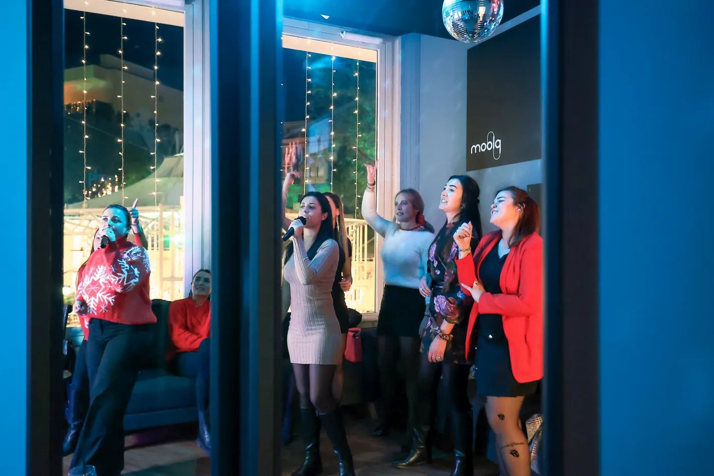 A group of friends singing in a private karaoke room at Mammamia